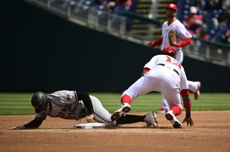 Apr 17, 2021; Washington, District of Columbia, USA;  Arizona Diamondbacks left fielder Tim Locastro (16) slides through the plate after being tagged out by Washington Nationals second baseman Starlin Castro (13) during the third inning at Nationals Park. Mandatory Credit: Tommy Gilligan-USA TODAY Sports