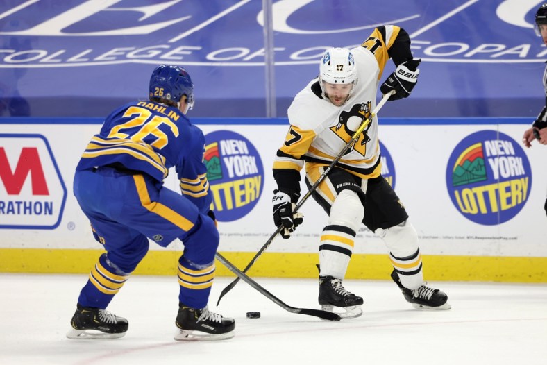 Apr 17, 2021; Buffalo, New York, USA;  Pittsburgh Penguins right wing Bryan Rust (17) skates up ice with the puck as Buffalo Sabres defenseman Rasmus Dahlin (26) knocks it off his stick during the first period at KeyBank Center. Mandatory Credit: Timothy T. Ludwig-USA TODAY Sports