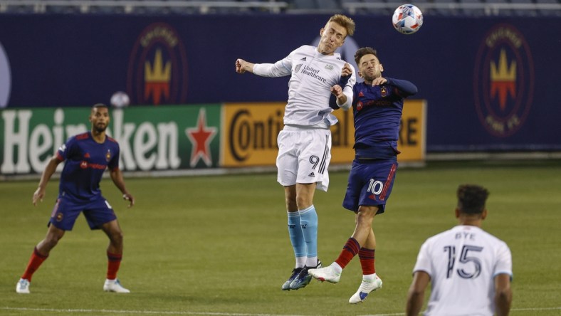 Apr 17, 2021; Chicago, Illinois, USA; New England Revolution forward Adam Buksa (9) battles for the ball with Chicago Fire midfielder Alvaro Medran (10) during the first half at Soldier Field. Mandatory Credit: Kamil Krzaczynski-USA TODAY Sports