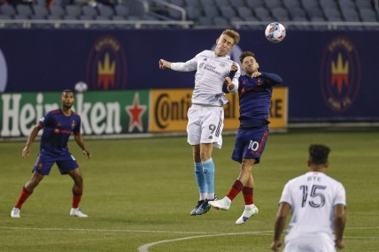 Apr 17, 2021; Chicago, Illinois, USA; New England Revolution forward Adam Buksa (9) battles for the ball with Chicago Fire midfielder Alvaro Medran (10) during the first half at Soldier Field. Mandatory Credit: Kamil Krzaczynski-USA TODAY Sports