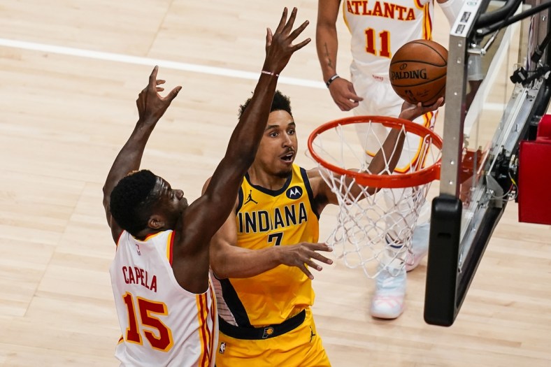 Apr 18, 2021; Atlanta, Georgia, USA; Indiana Pacers guard Malcolm Brogdon (7) takes the ball to the basket against Atlanta Hawks center Clint Capela (15) during the first quarter at State Farm Arena. Mandatory Credit: Dale Zanine-USA TODAY Sports