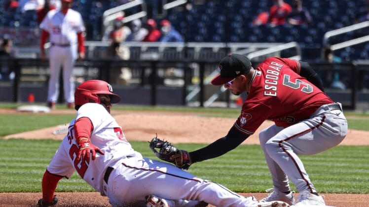 Apr 18, 2021; Washington, District of Columbia, USA; Washington Nationals left fielder Juan Soto (22) is tagged out attempting to advance to third base by Arizona Diamondbacks third baseman Eduardo Escobar (5) in the first inning at Nationals Park. Mandatory Credit: Geoff Burke-USA TODAY Sports
