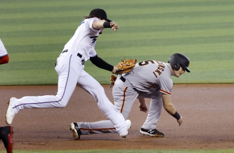 Apr 18, 2021; Miami, Florida, USA;  Miami Marlins infielder Brian Anderson (15) tags out San Francisco Giants baserunner Mike Yastrzemski (5) during the first inning at loanDepot Park. Mandatory Credit: Rhona Wise-USA TODAY Sports