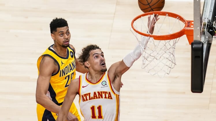 Apr 18, 2021; Atlanta, Georgia, USA; Atlanta Hawks guard Trae Young (11) lays in a basket behind Indiana Pacers guard Jeremy Lamb (26) during the second half at State Farm Arena. Mandatory Credit: Dale Zanine-USA TODAY Sports