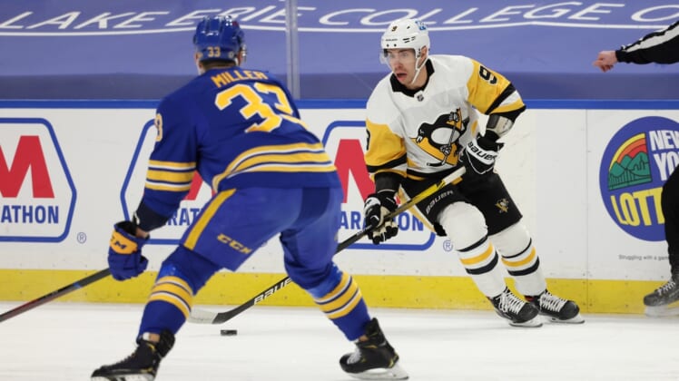 Apr 18, 2021; Buffalo, New York, USA;  Pittsburgh Penguins center Evan Rodrigues (9) controls the puck against Buffalo Sabres defenseman Colin Miller (33) during the first period at KeyBank Center. Mandatory Credit: Timothy T. Ludwig-USA TODAY Sports
