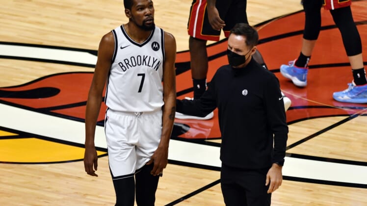Apr 18, 2021; Miami, Florida, USA; Brooklyn Nets forward Kevin Durant (7) holds his left leg as head coach Steve Nash assists him from the court during the first half of a game against the Miami Heat at American Airlines Arena. Mandatory Credit: Jim Rassol-USA TODAY Sports