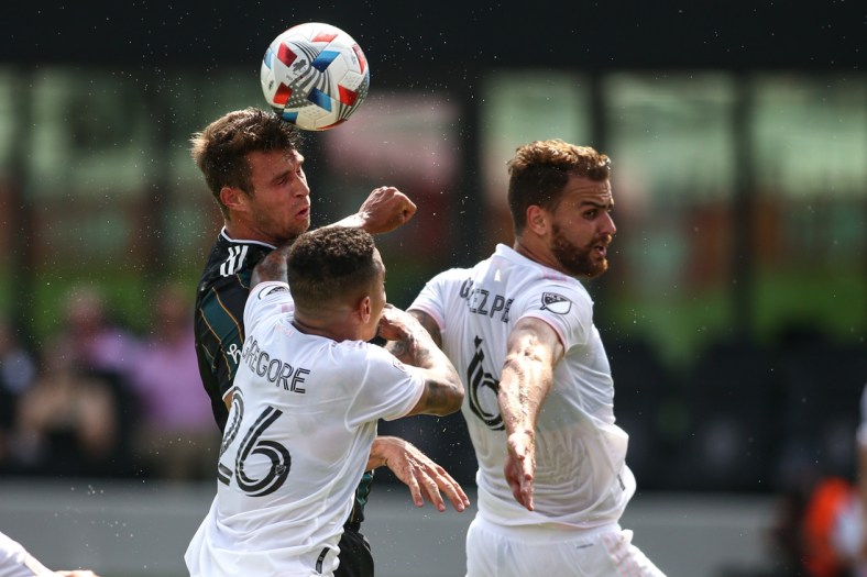 Apr 18, 2021; Fort Lauderdale, FL, USA; Los Angeles Galaxy forward Nick DePuy (20) heads the ball against Inter Miami CF midfielder Gregore (26) and midfielder Leandro Pirez (6) during the first half at DRV PNK Stadium. Mandatory Credit: Sam Navarro-USA TODAY Sports