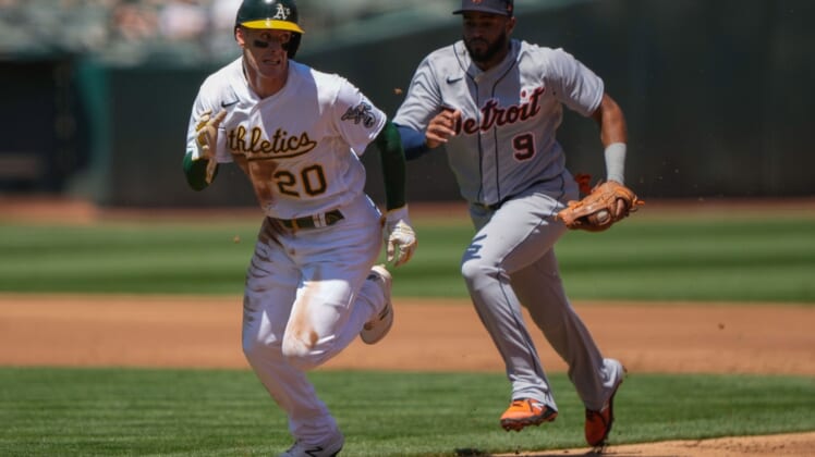 Apr 18, 2021; Oakland, California, USA;  Oakland Athletics left fielder Mark Canha (20) is chased by Detroit Tigers shortstop Willi Castro (9) during the first inning at RingCentral Coliseum. Mandatory Credit: Stan Szeto-USA TODAY Sports