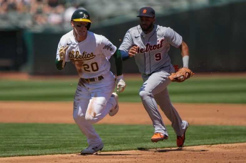 Apr 18, 2021; Oakland, California, USA;  Oakland Athletics left fielder Mark Canha (20) is chased by Detroit Tigers shortstop Willi Castro (9) during the first inning at RingCentral Coliseum. Mandatory Credit: Stan Szeto-USA TODAY Sports