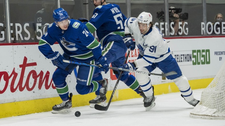 Apr 18, 2021; Vancouver, British Columbia, CAN; Vancouver Canucks forward Jimmy Vesey (24) checks Toronto Maple Leafs forward John Tavares (91) in the first period at Rogers Arena. Mandatory Credit: Bob Frid-USA TODAY Sports