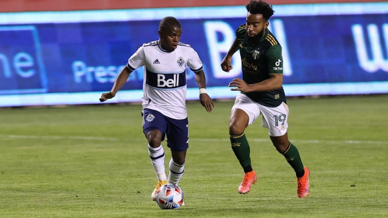 Apr 18, 2021; Sandy, Utah, USA; Vancouver Whitecaps FC forward Deiber Caicedo (7) plays the ball while defended by Portland Timbers midfielder Eryk Williamson (19) during the first half at Rio Tinto Stadium. Mandatory Credit: Rob Gray-USA TODAY Sports