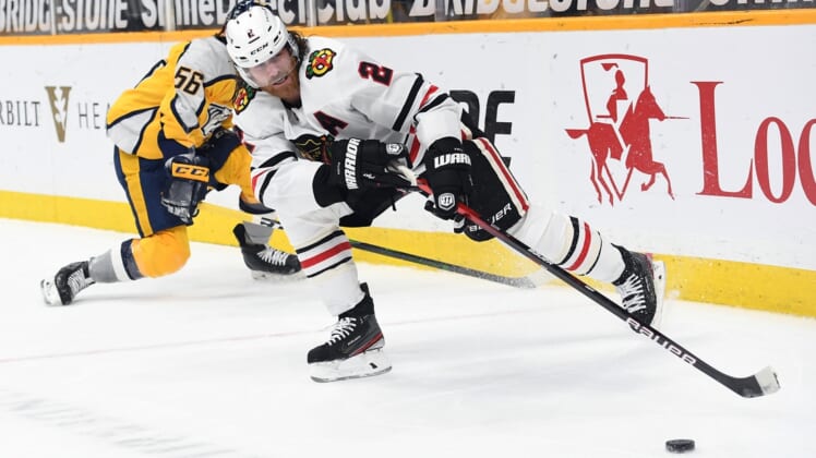 Apr 19, 2021; Nashville, Tennessee, USA; Chicago Blackhawks defenseman Duncan Keith (2) plays the puck after taking it from Nashville Predators left wing Erik Haula (56) during the first period at Bridgestone Arena. Mandatory Credit: Christopher Hanewinckel-USA TODAY Sports