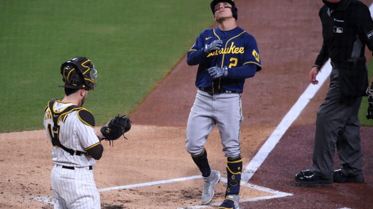 Apr 19, 2021; San Diego, California, USA; Milwaukee Brewers shortstop Luis Urias (2) looks up as he steps on home plate after hitting a home run as San Diego Padres catcher Victor Caratini (17) looks on during the third inning at Petco Park. Mandatory Credit: Orlando Ramirez-USA TODAY Sports