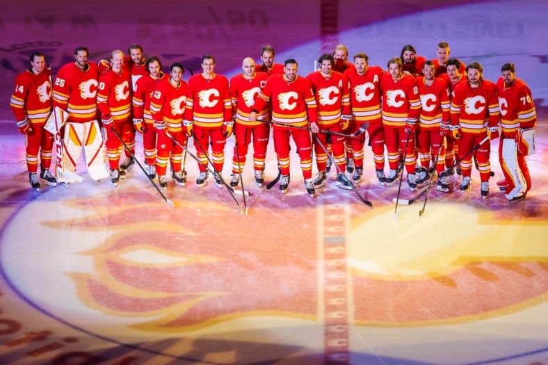 Apr 19, 2021; Calgary, Alberta, CAN; Calgary Flames left wing Milan Lucic (17) poses for a photo with teammates as he was honored for his 1000 NHL hockey game prior to the game between the Calgary Flames and the Ottawa Senators at Scotiabank Saddledome. Mandatory Credit: Sergei Belski-USA TODAY Sports