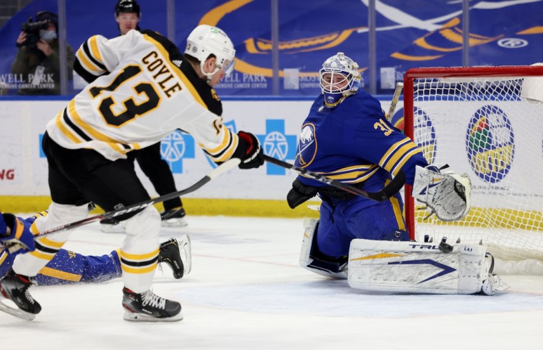 Apr 20, 2021; Buffalo, New York, USA;  Buffalo Sabres goaltender Dustin Tokarski (31) makes a pad save on Boston Bruins center Charlie Coyle (13) during the first period at KeyBank Center. Mandatory Credit: Timothy T. Ludwig-USA TODAY Sports