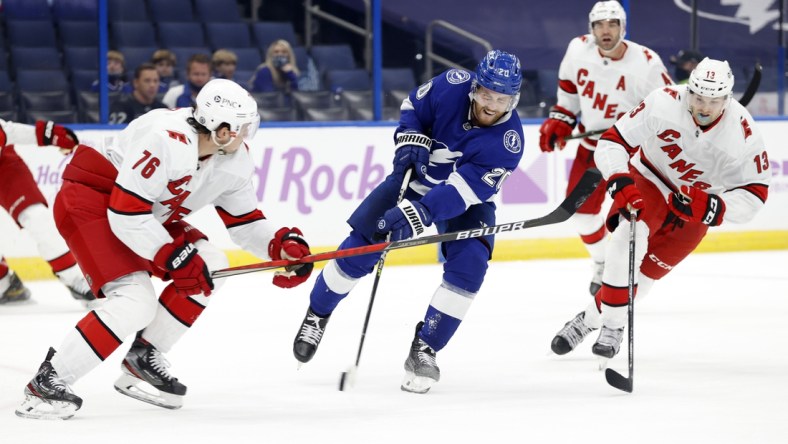 Apr 20, 2021; Tampa, Florida, USA; Tampa Bay Lightning center Blake Coleman (20) shoots as Carolina Hurricanes defenseman Brady Skjei (76) defends during the first period at Amalie Arena. Mandatory Credit: Kim Klement-USA TODAY Sports