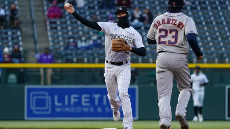 Apr 20, 2021; Denver, Colorado, USA; Colorado Rockies second baseman Ryan McMahon (24) turns a double play on Houston Astros left fielder Michael Brantley (23) in the first inning against the Houston Astros at Coors Field. Mandatory Credit: Ron Chenoy-USA TODAY Sports