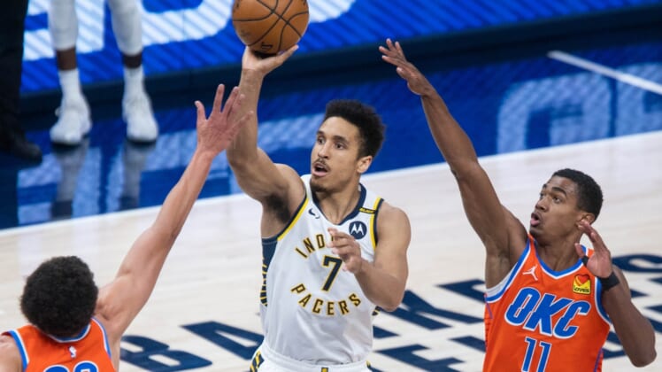 Apr 21, 2021; Indianapolis, Indiana, USA; Indiana Pacers guard Malcolm Brogdon (7) shoots the ball while Oklahoma City Thunder center Isaiah Roby (22) and guard Theo Maledon (11) defend in the second quarter at Bankers Life Fieldhouse. Mandatory Credit: Trevor Ruszkowski-USA TODAY Sports