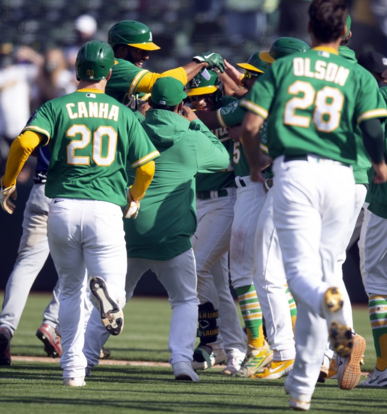 Apr 21, 2021; Oakland, California, USA; Oakland Athletics players mob Ram  n Laureano (22) after his ground ball was misplayed by the Minnesota Twins into a game-winning hit during the tenth inning of a Major League Baseball game at RingCentral Coliseum. Mandatory Credit: D. Ross Cameron-USA TODAY Sports