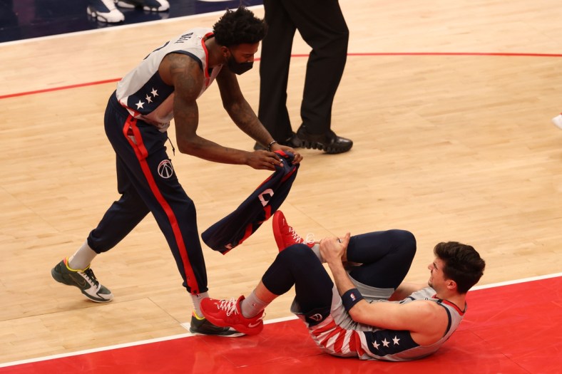 Apr 21, 2021; Washington, District of Columbia, USA; Washington Wizards forward Deni Avdija (9) is assisted by Wizards center Jordan Bell (7) after being injured against the Golden State Warriors in the second quarter at Capital One Arena. Mandatory Credit: Geoff Burke-USA TODAY Sports