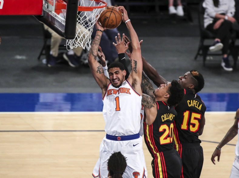 Apr 21, 2021; New York, New York, USA; New York Knicks forward Obi Toppin (1) grabs a rebound against Atlanta Hawks forward John Collins (20) and center Clint Capela (15) in the second quarter at Madison Square Garden. Mandatory Credit: Wendell Cruz-USA TODAY Sports