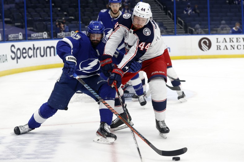 Apr 22, 2021; Tampa, Florida, USA; Tampa Bay Lightning left wing Alex Killorn (17) and Columbus Blue Jackets defenseman Vladislav Gavrikov (44) fight to control the puck during the first period at Amalie Arena. Mandatory Credit: Kim Klement-USA TODAY Sports