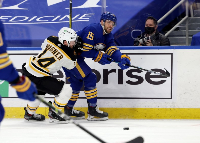 Apr 23, 2021; Buffalo, New York, USA;  Buffalo Sabres center Riley Sheahan (15) makes a pass as Boston Bruins right wing Chris Wagner (14) defends during the first period at KeyBank Center. Mandatory Credit: Timothy T. Ludwig-USA TODAY Sports