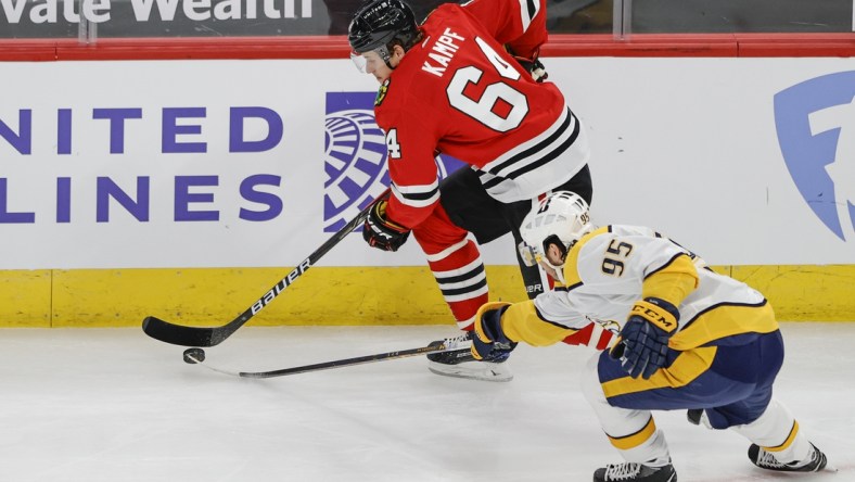 Apr 23, 2021; Chicago, Illinois, USA; Chicago Blackhawks center David Kampf (64) keeps the puck away from Nashville Predators center Matt Duchene (95) during the first period at United Center. Mandatory Credit: Kamil Krzaczynski-USA TODAY Sports