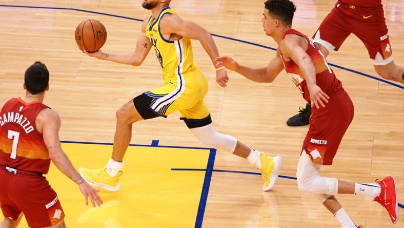 Apr 23, 2021; San Francisco, California, USA; Golden State Warriors guard Stephen Curry (30) drives in ahead of Denver Nuggets forward Michael Porter Jr. (1) during the second quarter at Chase Center. Mandatory Credit: Kelley L Cox-USA TODAY Sports