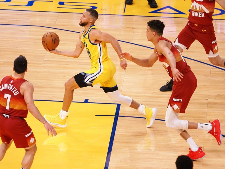 Apr 23, 2021; San Francisco, California, USA; Golden State Warriors guard Stephen Curry (30) drives in ahead of Denver Nuggets forward Michael Porter Jr. (1) during the second quarter at Chase Center. Mandatory Credit: Kelley L Cox-USA TODAY Sports
