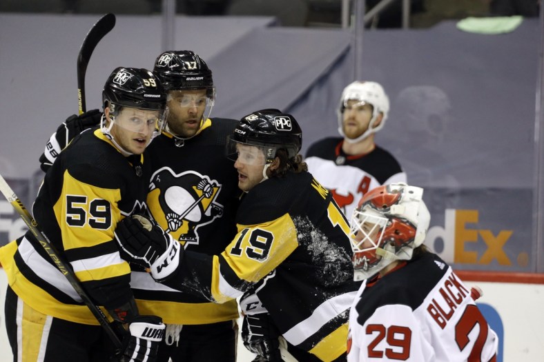 Apr 24, 2021; Pittsburgh, Pennsylvania, USA;  Pittsburgh Penguins center Jared McCann (19) celebrates his power play goal against New Jersey Devils goaltender Mackenzie Blackwood (29) with Pens left wing Jake Guentzel (59) and right wing Bryan Rust (17) during the first period at PPG Paints Arena. Mandatory Credit: Charles LeClaire-USA TODAY Sports