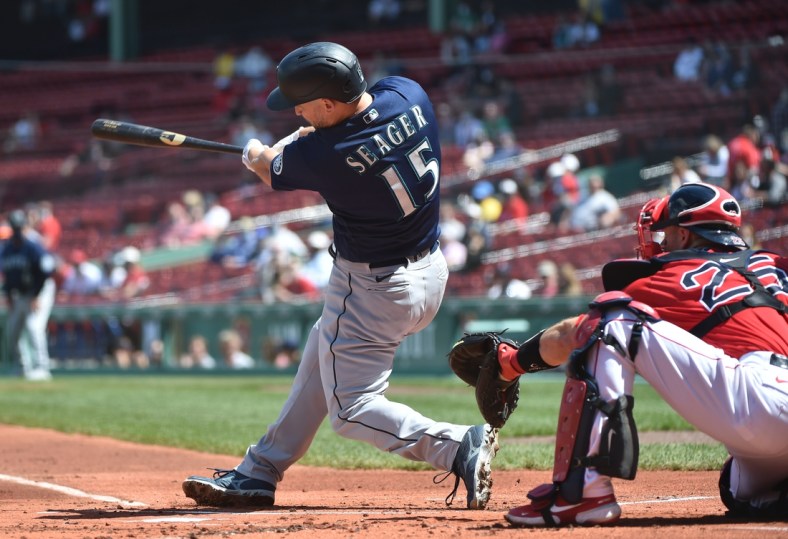 Apr 24, 2021; Boston, Massachusetts, USA;  Seattle Mariners third baseman Kyle Seager (15) hits an RBI single during the first inning against the Boston Red Sox at Fenway Park. Mandatory Credit: Bob DeChiara-USA TODAY Sports