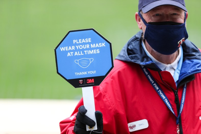 Apr 24, 2021; Minneapolis, Minnesota, USA; A Target Field employee holds a sign reminding fans to wear their mask in the first inning during a game between the Pittsburgh Pirates and Minnesota Twins at Target Field. Mandatory Credit: David Berding-USA TODAY Sports