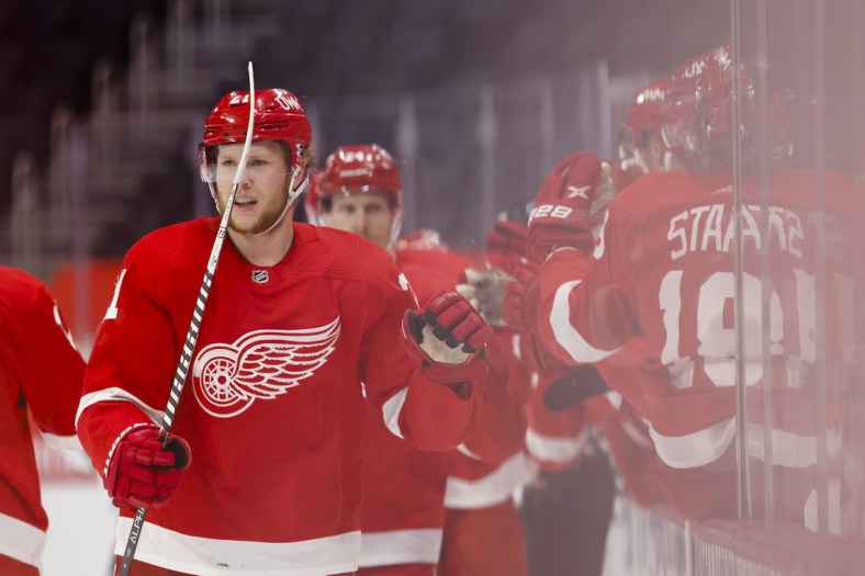 Apr 24, 2021; Detroit, Michigan, USA; Detroit Red Wings defenseman Dennis Cholowski (21) is congratulated by teammates after scoring against the Dallas Stars in the first period at Little Caesars Arena. Mandatory Credit: Rick Osentoski-USA TODAY Sports