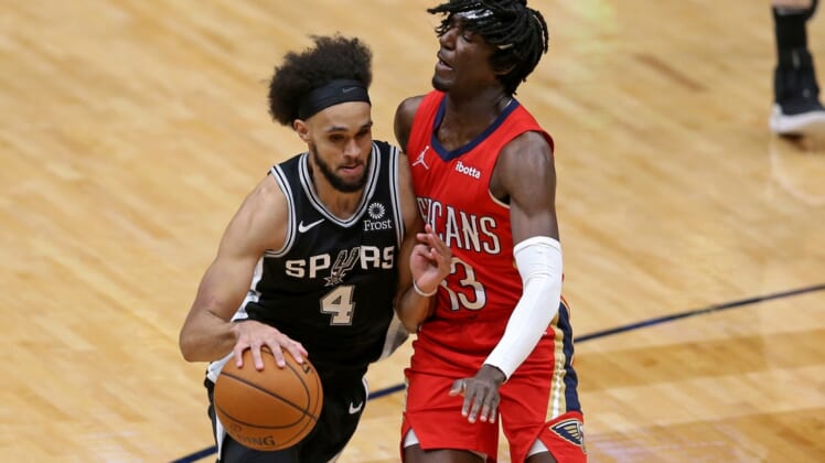 Apr 24, 2021; New Orleans, Louisiana, USA; San Antonio Spurs guard Derrick White (4) tries to drive around New Orleans Pelicans guard Kira Lewis Jr. (13) during the fourth quarter at the Smoothie King Center. Mandatory Credit: Chuck Cook-USA TODAY Sports