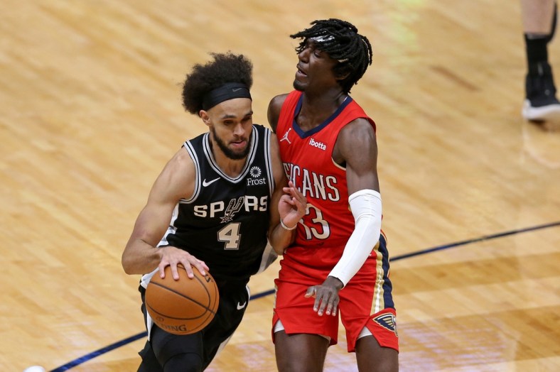 Apr 24, 2021; New Orleans, Louisiana, USA; San Antonio Spurs guard Derrick White (4) tries to drive around New Orleans Pelicans guard Kira Lewis Jr. (13) during the fourth quarter at the Smoothie King Center. Mandatory Credit: Chuck Cook-USA TODAY Sports