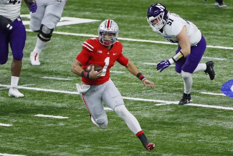 Ohio State Buckeyes quarterback Justin Fields (1) rushes upfield ahead of Northwestern Wildcats linebacker Blake Gallagher (51) during the first quarter of the Big Ten Championship football game at Lucas Oil Stadium in Indianapolis on Saturday, Dec. 19, 2020.Big Ten Championship Ohio State Northwestern