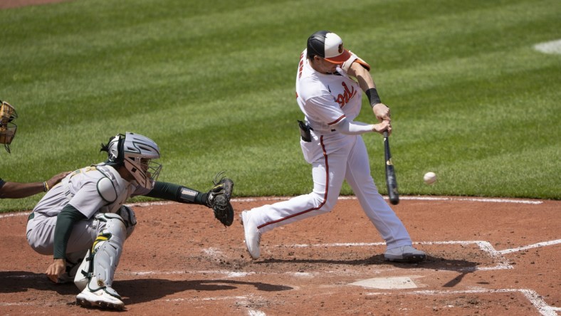 Apr 25, 2021; Baltimore, Maryland, USA; Baltimore Orioles right fielder Austin Hays (21) hits a home run during the fourth inning against the Oakland Athletics at Oriole Park at Camden Yards. Mandatory Credit: Gregory Fisher-USA TODAY Sports