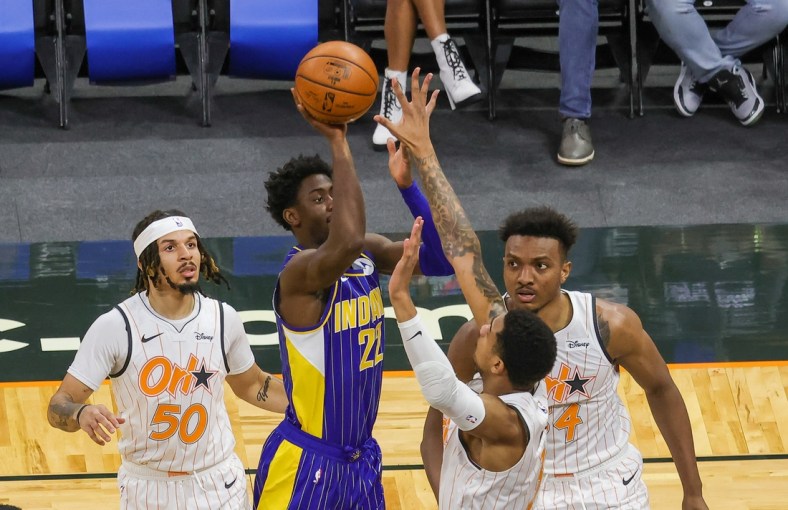 Apr 25, 2021; Orlando, Florida, USA; Indiana Pacers guard Caris LeVert (22) shoots the ball over Orlando Magic forward Chuma Okeke (3) and center Wendell Carter Jr. (34) as Orlando Magic guard Cole Anthony (50) looks on during the first quarter at Amway Center. Mandatory Credit: Mike Watters-USA TODAY Sports