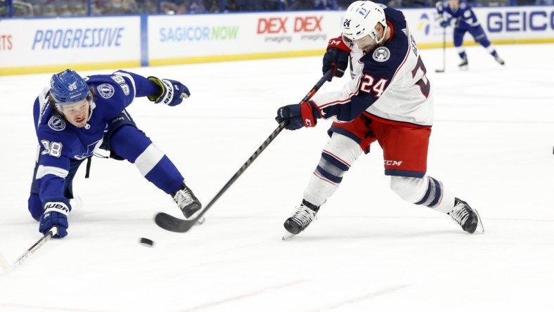 Apr 25, 2021; Tampa, Florida, USA;  Columbus Blue Jackets left wing Nathan Gerbe (24) passes the puck as Tampa Bay Lightning defenseman Mikhail Sergachev (98) during the second period at Amalie Arena. Mandatory Credit: Kim Klement-USA TODAY Sports