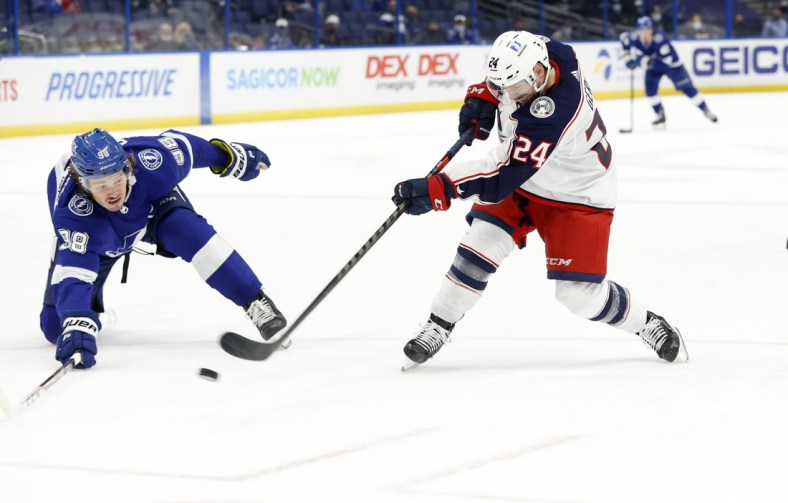 Apr 25, 2021; Tampa, Florida, USA;  Columbus Blue Jackets left wing Nathan Gerbe (24) passes the puck as Tampa Bay Lightning defenseman Mikhail Sergachev (98) during the second period at Amalie Arena. Mandatory Credit: Kim Klement-USA TODAY Sports