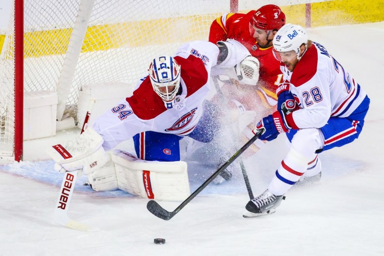 Apr 26, 2021; Calgary, Alberta, CAN; Montreal Canadiens goaltender Jake Allen (34) makes a save against Calgary Flames center Mikael Backlund (11) during the first period at Scotiabank Saddledome. Mandatory Credit: Sergei Belski-USA TODAY Sports