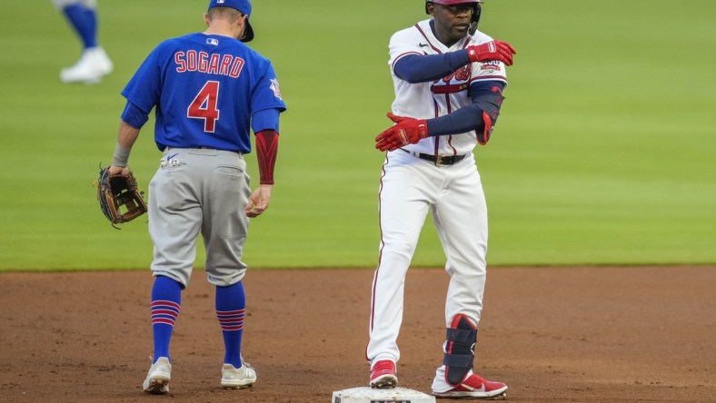 Apr 26, 2021; Cumberland, Georgia, USA; Atlanta Braves center fielder Guillermo Heredia (R) reacts next to Chicago Cubs infielder Eric Sogard (4) after hitting an RBI double during the first inning at Truist Park. Mandatory Credit: Dale Zanine-USA TODAY Sports