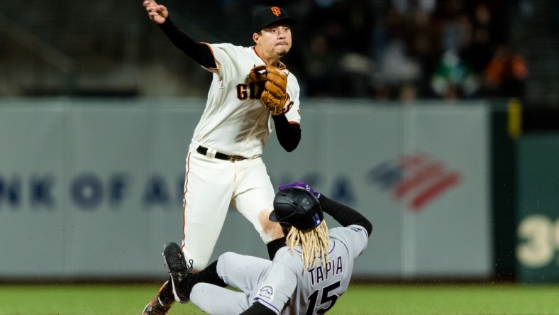 Apr 26, 2021; San Francisco, California, USA;  San Francisco Giants shortstop Mauricio Dubon (1) tags Colorado Rockies left fielder Raimel Tapia (15) but is late for the double play at first base in the sixth inning at Oracle Park. Mandatory Credit: John Hefti-USA TODAY Sports