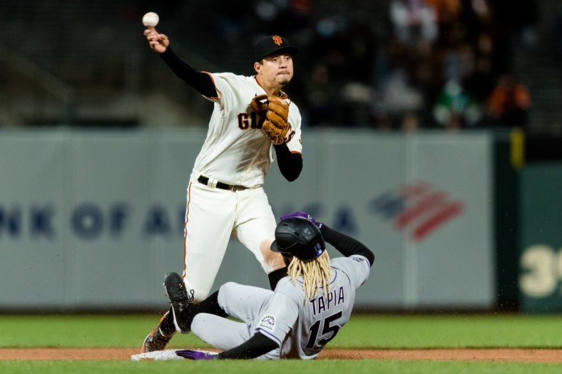 Apr 26, 2021; San Francisco, California, USA;  San Francisco Giants shortstop Mauricio Dubon (1) tags Colorado Rockies left fielder Raimel Tapia (15) but is late for the double play at first base in the sixth inning at Oracle Park. Mandatory Credit: John Hefti-USA TODAY Sports