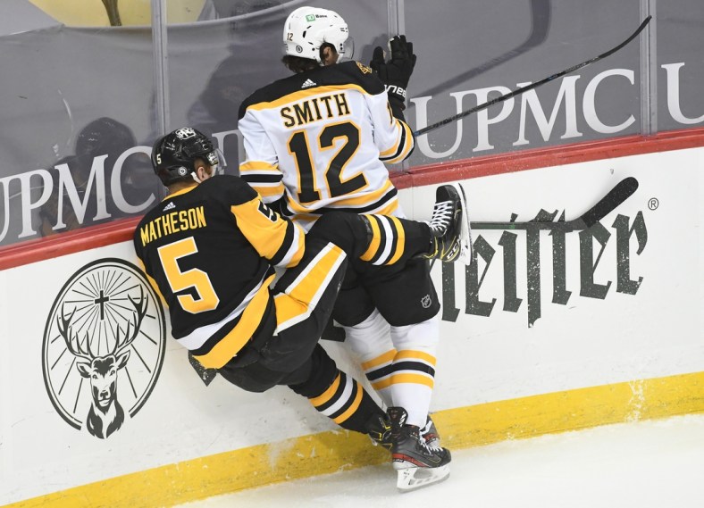 Apr 27, 2021; Pittsburgh, Pennsylvania, USA;  Boston Bruins center Craig Smith (12) and Pittsburgh Penguins defenseman  Mike Matheson (5) crash into each other during the first period at PPG Paints Arena. Mandatory Credit: Philip G. Pavely-USA TODAY Sports