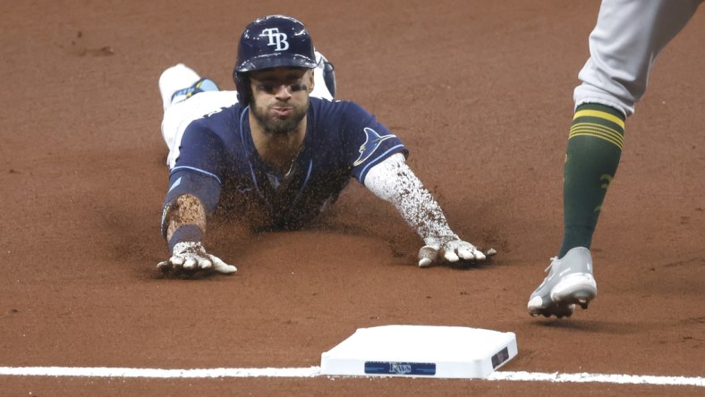 Apr 27, 2021; St. Petersburg, Florida, USA; Tampa Bay Rays center fielder Kevin Kiermaier (39) slides into third base as he triples during the first inning against the Oakland Athletics at Tropicana Field. Mandatory Credit: Kim Klement-USA TODAY Sports