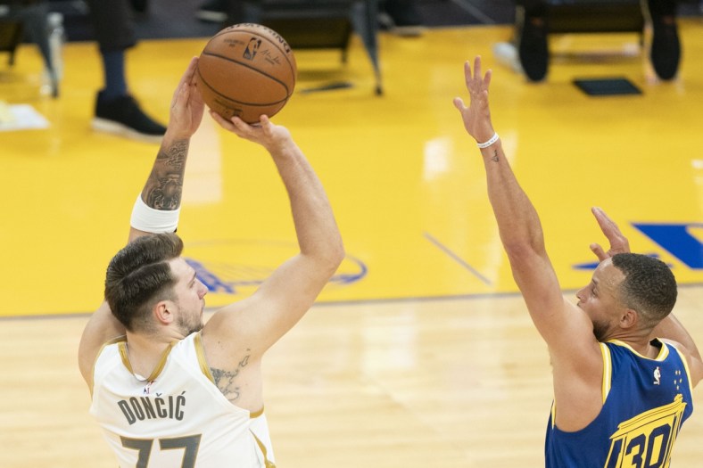 April 27, 2021; San Francisco, California, USA; Dallas Mavericks guard Luka Doncic (77) shoots the basketball against Golden State Warriors guard Stephen Curry (30) during the second quarter at Chase Center. Mandatory Credit: Kyle Terada-USA TODAY Sports