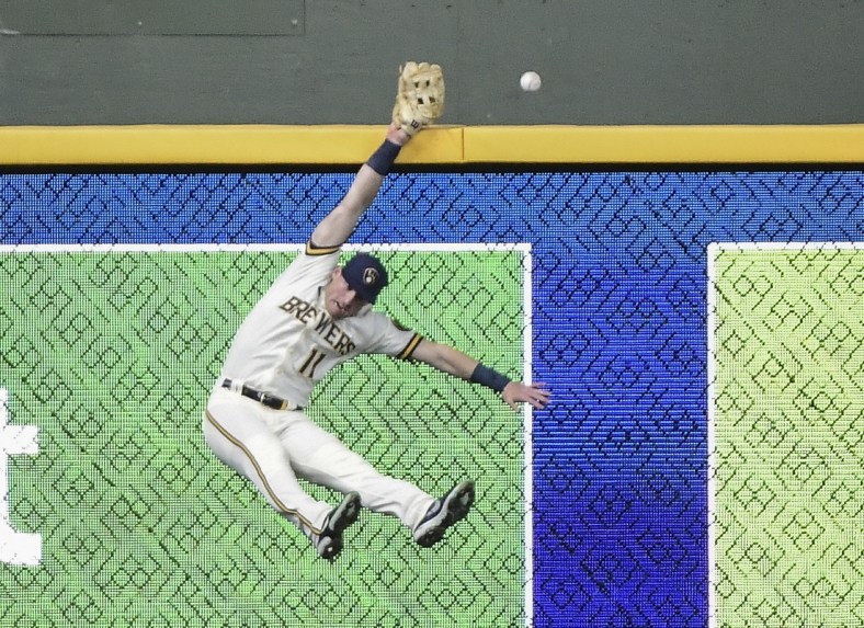 Apr 28, 2021; Milwaukee, Wisconsin, USA;  Milwaukee Brewers left fielder Billy McKinney (11) misses catching a ball hit by Miami Marlins first baseman Jesus Aguilar (not pictured) for a 3 run home run in the fourth inning at American Family Field. Mandatory Credit: Benny Sieu-USA TODAY Sports