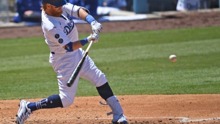 Apr 28, 2021; Los Angeles, California, USA;  Los Angeles Dodgers third baseman Justin Turner (10) as he hits a solo home run in the third inning of the game against the Cincinnati Reds at Dodger Stadium. Mandatory Credit: Jayne Kamin-Oncea-USA TODAY Sports